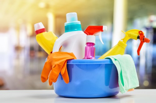 Modern office cleaner sanitising desks in Knightsbridge
